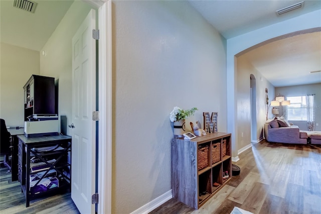 6648 Castle Green Pl, Zephyrhills, FL 33541 - hallway featuring arched walkways and wood finished floors