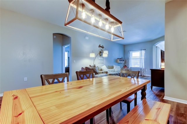 6648 Castle Green Pl, Zephyrhills, FL 33541 - dining space featuring arched walkways and wood finished floors