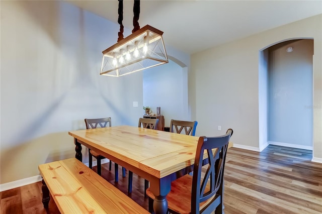 6648 Castle Green Pl, Zephyrhills, FL 33541 - dining space with arched walkways and wood finished floors