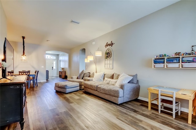 6648 Castle Green Pl, Zephyrhills, FL 33541 - living area with arched walkways and wood finished floors