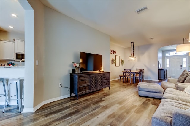 6648 Castle Green Pl, Zephyrhills, FL 33541 - living room featuring arched walkways, light wood-style flooring, and recessed lighting
