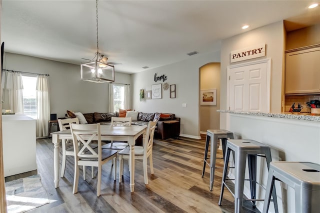 6648 Castle Green Pl, Zephyrhills, FL 33541 - dining space with arched walkways, light wood-style flooring, recessed lighting, and a chandelier