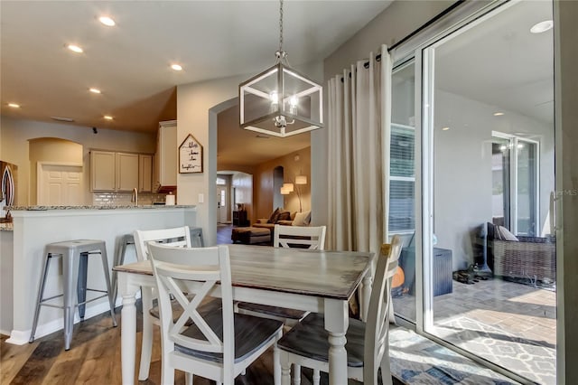 6648 Castle Green Pl, Zephyrhills, FL 33541 - dining room with recessed lighting, arched walkways, and light wood-style flooring