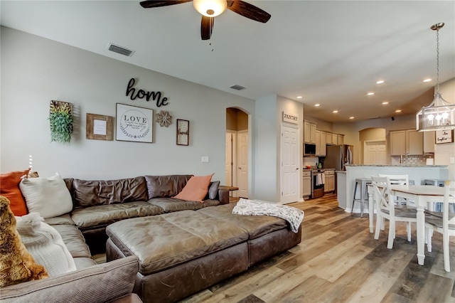 6648 Castle Green Pl, Zephyrhills, FL 33541 - living area featuring arched walkways, a ceiling fan, light wood-style flooring, and recessed lighting