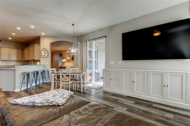 6648 Castle Green Pl, Zephyrhills, FL 33541 - living room featuring arched walkways, dark wood-style floors, and recessed lighting