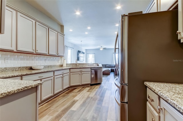 6648 Castle Green Pl, Zephyrhills, FL 33541 - kitchen with appliances with stainless steel finishes, open floor plan, light wood-style flooring, a peninsula, and recessed lighting