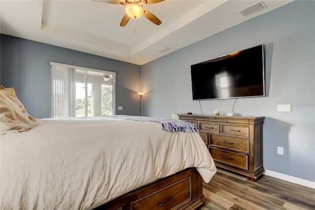 6648 Castle Green Pl, Zephyrhills, FL 33541 - bedroom with dark wood finished floors, a raised ceiling, and ceiling fan