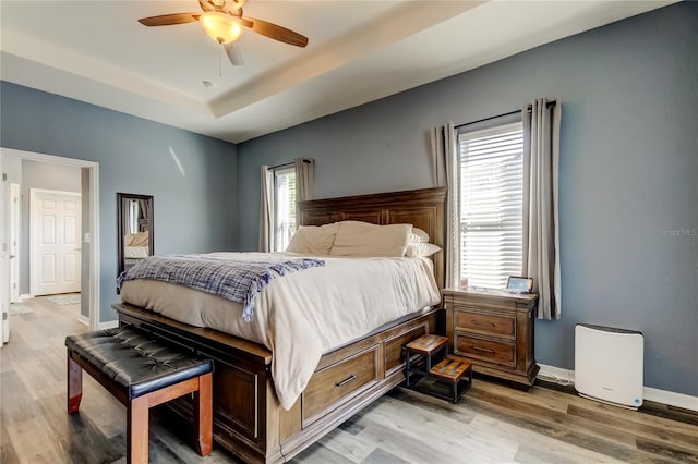 6648 Castle Green Pl, Zephyrhills, FL 33541 - bedroom featuring light wood-type flooring, a raised ceiling, and ceiling fan