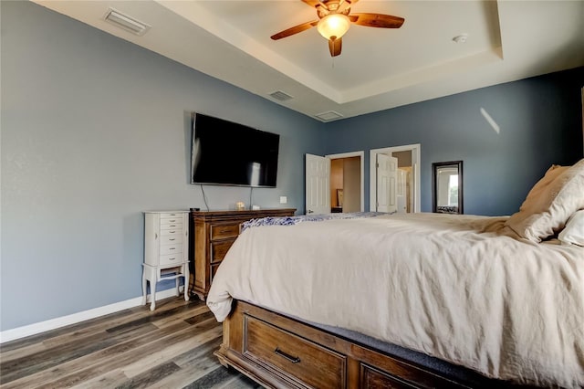 6648 Castle Green Pl, Zephyrhills, FL 33541 - bedroom with a raised ceiling, wood finished floors, and ceiling fan