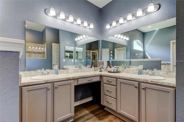 6648 Castle Green Pl, Zephyrhills, FL 33541 - bathroom featuring a stall shower, double vanity, wood finished floors, and a textured wall