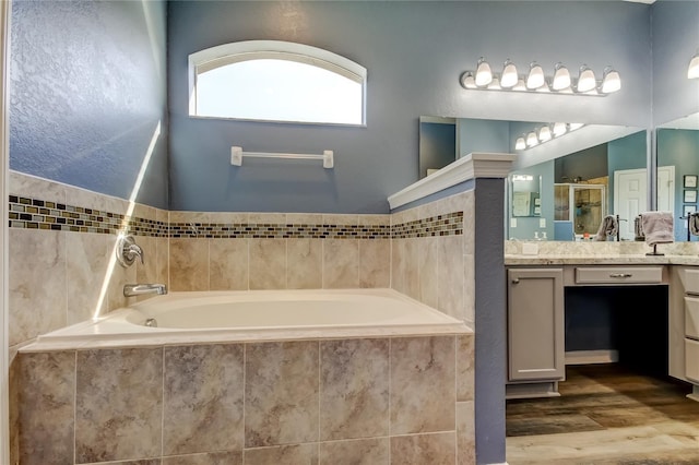 6648 Castle Green Pl, Zephyrhills, FL 33541 - full bath with vanity, a bath, a stall shower, and wood finished floors