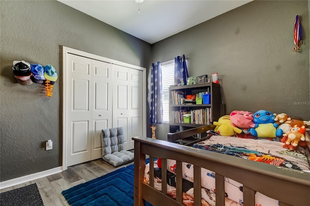 6648 Castle Green Pl, Zephyrhills, FL 33541 - bedroom featuring wood finished floors, a closet, and a textured wall