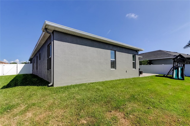 6648 Castle Green Pl, Zephyrhills, FL 33541 - rear view of house with a playground, a fenced backyard, and stucco siding