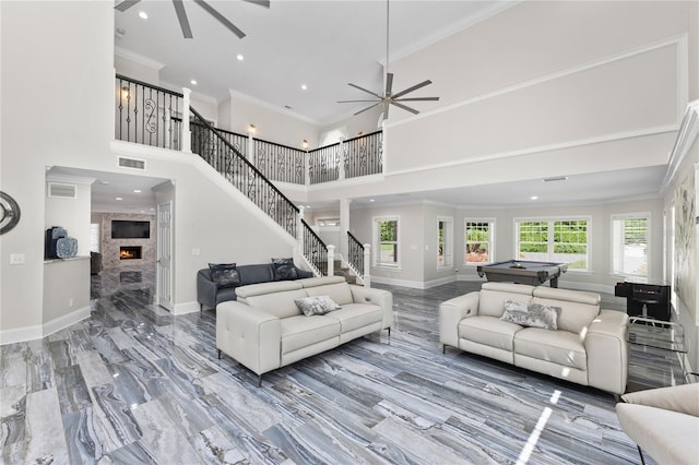 3663 Berger Rd, Lutz, FL 33548 - living area featuring a ceiling fan, stairway, crown molding, a fireplace, and a towering ceiling