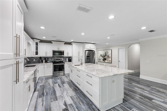 3663 Berger Rd, Lutz, FL 33548 - kitchen featuring appliances with stainless steel finishes, arched walkways, ornamental molding, recessed lighting, and decorative backsplash