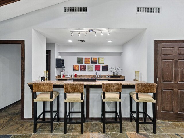 13285 Arbor Pointe Cir Unit 202, Tampa, FL 33617 - kitchen featuring a peninsula, stone finish floors, a breakfast bar area, and light stone counters