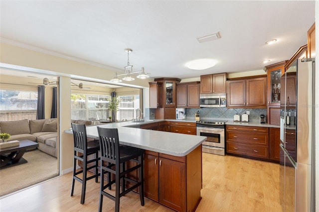218 N Bay Hills Blvd, Safety Harbor, FL 34695 - kitchen with stainless steel appliances, light countertops, glass insert cabinets, backsplash, and a breakfast bar