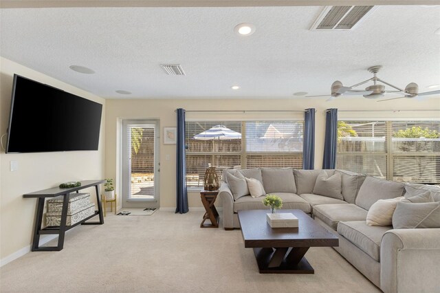 218 N Bay Hills Blvd, Safety Harbor, FL 34695 - living area featuring light colored carpet, healthy amount of natural light, a textured ceiling, and a ceiling fan