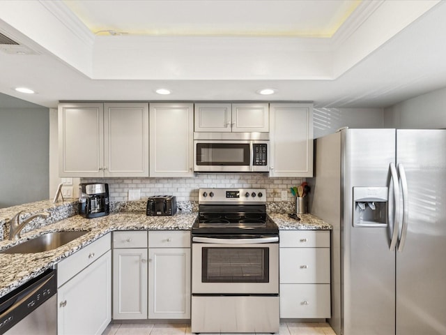 214 Meadow Ln Unit 214, Oldsmar, FL 34677 - kitchen with stainless steel appliances, a raised ceiling, decorative backsplash, light stone counters, and recessed lighting