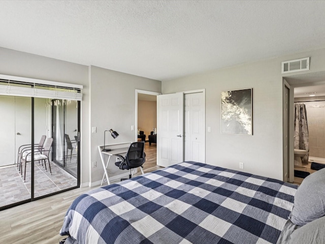 214 Meadow Ln Unit 214, Oldsmar, FL 34677 - bedroom with light wood-style flooring, access to exterior, and a textured ceiling