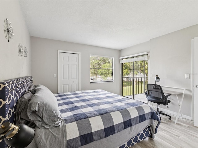 214 Meadow Ln Unit 214, Oldsmar, FL 34677 - bedroom featuring access to outside, wood finished floors, a textured ceiling, and a closet