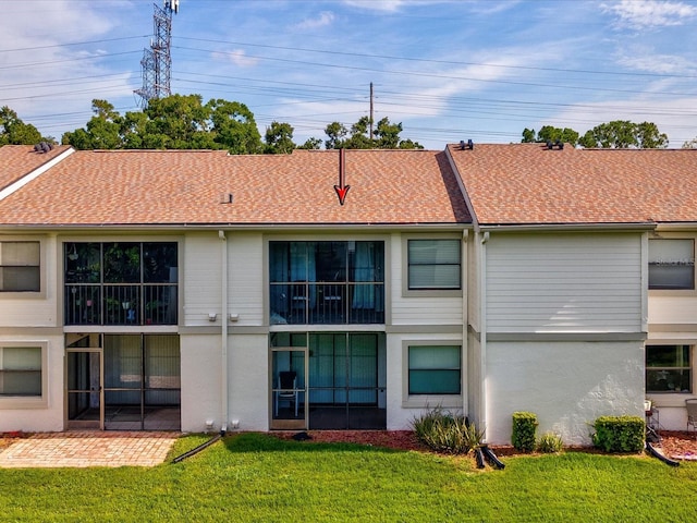214 Meadow Ln Unit 214, Oldsmar, FL 34677 - rear view of house featuring a lawn, a patio area, stucco siding, and a shingled roof
