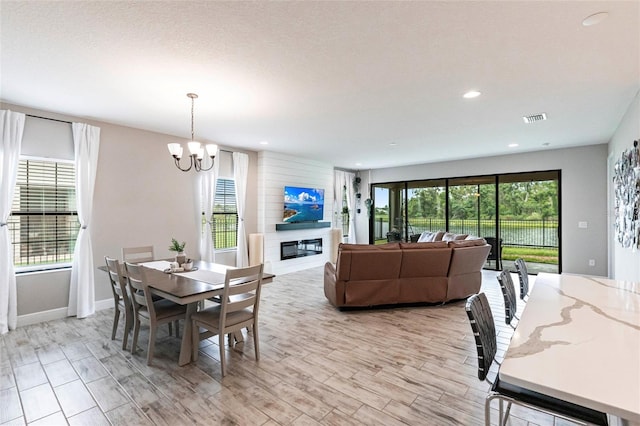 12646 Oak Hill Way, Parrish, FL 34219 - dining space with a chandelier, a glass covered fireplace, and recessed lighting