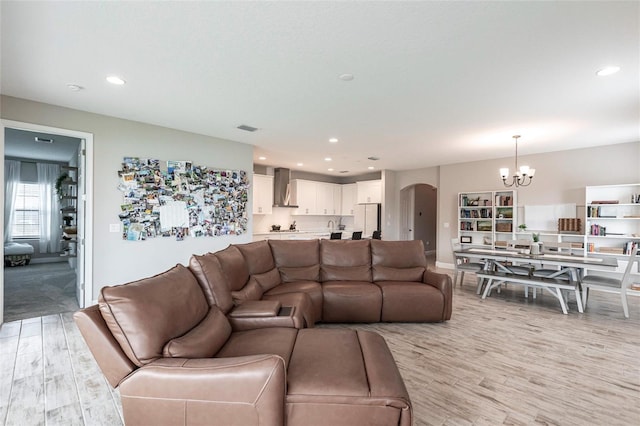 12646 Oak Hill Way, Parrish, FL 34219 - living room with arched walkways, a chandelier, light wood-style floors, and recessed lighting