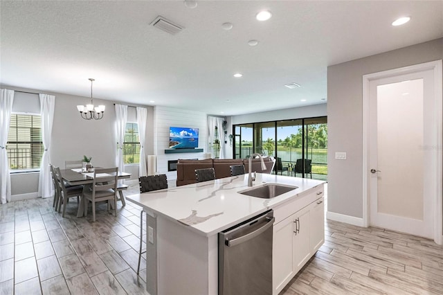 12646 Oak Hill Way, Parrish, FL 34219 - kitchen with stainless steel dishwasher, a chandelier, white cabinets, a center island with sink, and open floor plan
