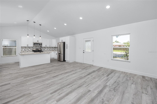 2859 38th Ave N, Saint Petersburg, FL 33713 - kitchen featuring appliances with stainless steel finishes, open floor plan, lofted ceiling, light countertops, and white cabinetry