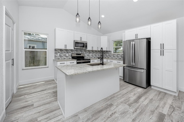 2859 38th Ave N, Saint Petersburg, FL 33713 - kitchen featuring stainless steel appliances, lofted ceiling, light wood-style floors, light stone countertops, and white cabinets