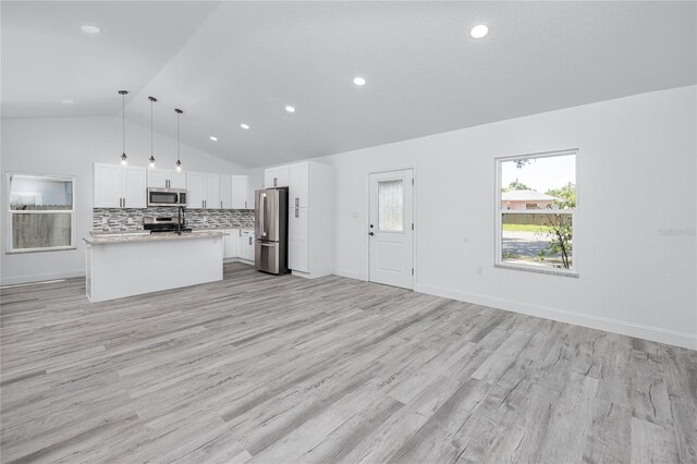 2859 38th Ave N, Saint Petersburg, FL 33713 - kitchen featuring appliances with stainless steel finishes, open floor plan, lofted ceiling, light countertops, and white cabinetry