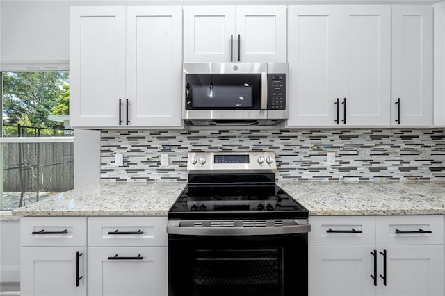 2859 38th Ave N, Saint Petersburg, FL 33713 - kitchen with stainless steel appliances, backsplash, and white cabinetry