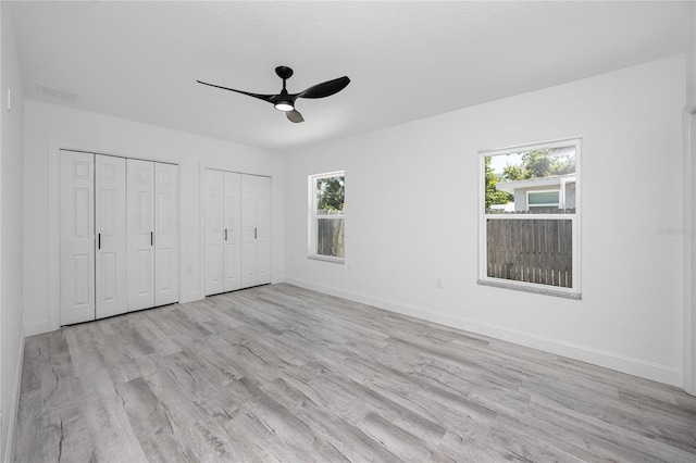 2859 38th Ave N, Saint Petersburg, FL 33713 - unfurnished bedroom with multiple windows, light wood finished floors, multiple closets, and a ceiling fan