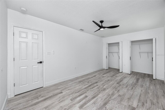 2859 38th Ave N, Saint Petersburg, FL 33713 - unfurnished bedroom featuring light wood-style flooring, two closets, a textured ceiling, and ceiling fan