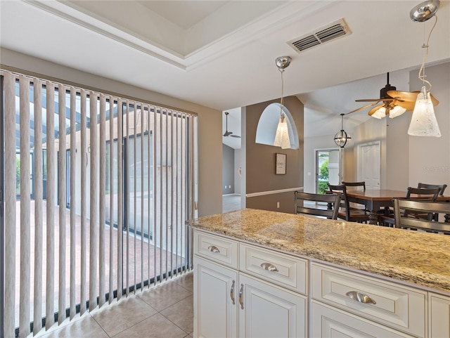 37147 Foxrun Pl, Zephyrhills, FL 33542 - kitchen with ceiling fan, light stone countertops, light tile patterned floors, and pendant lighting