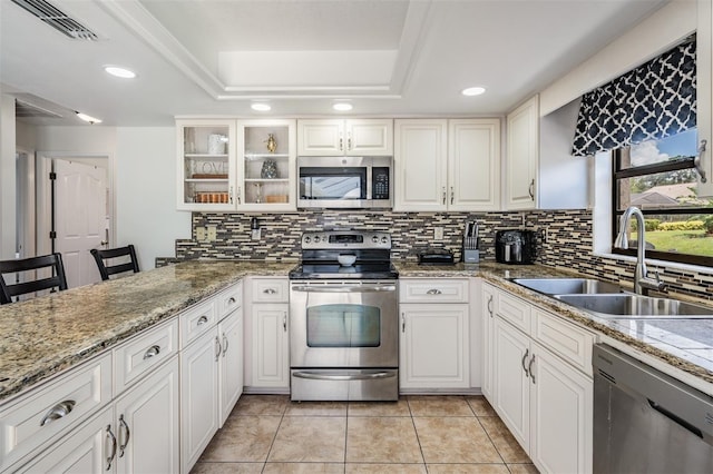 37147 Foxrun Pl, Zephyrhills, FL 33542 - kitchen featuring stainless steel appliances, a tray ceiling, tasteful backsplash, recessed lighting, and light tile patterned flooring