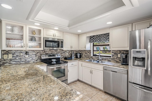 37147 Foxrun Pl, Zephyrhills, FL 33542 - kitchen with appliances with stainless steel finishes, a raised ceiling, recessed lighting, backsplash, and light tile patterned floors
