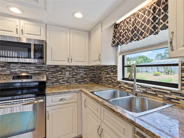37147 Foxrun Pl, Zephyrhills, FL 33542 - kitchen with appliances with stainless steel finishes, tasteful backsplash, white cabinets, recessed lighting, and light countertops