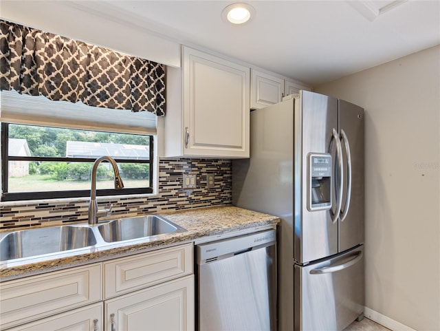 37147 Foxrun Pl, Zephyrhills, FL 33542 - kitchen with appliances with stainless steel finishes, decorative backsplash, white cabinets, light stone counters, and recessed lighting