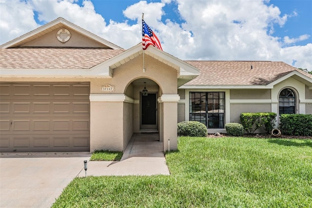 37147 Foxrun Pl, Zephyrhills, FL 33542 - traditional-style house with a shingled roof, a front yard, an attached garage, stucco siding, and driveway