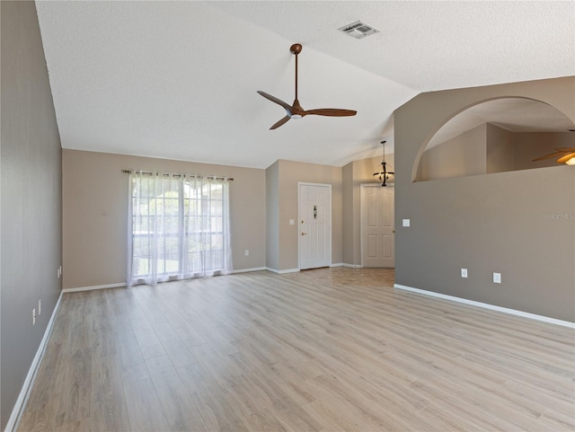 37147 Foxrun Pl, Zephyrhills, FL 33542 - unfurnished living room featuring ceiling fan, lofted ceiling, light wood-style flooring, and a textured ceiling