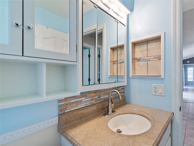 37147 Foxrun Pl, Zephyrhills, FL 33542 - bathroom with vanity, a textured ceiling, and decorative backsplash