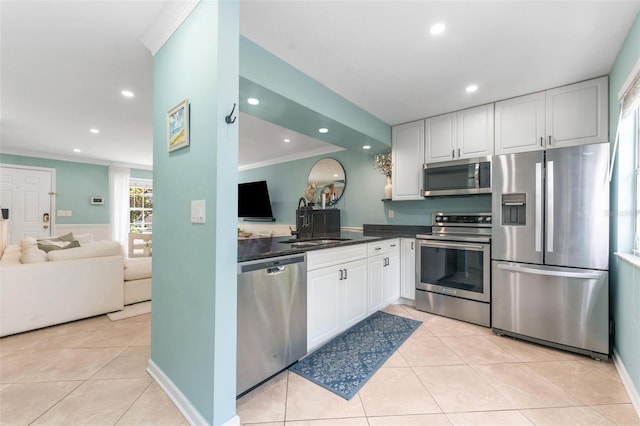 2809 W Platt St Unit 6, Tampa, FL 33609 - kitchen featuring stainless steel appliances, ornamental molding, white cabinets, light tile patterned flooring, and recessed lighting