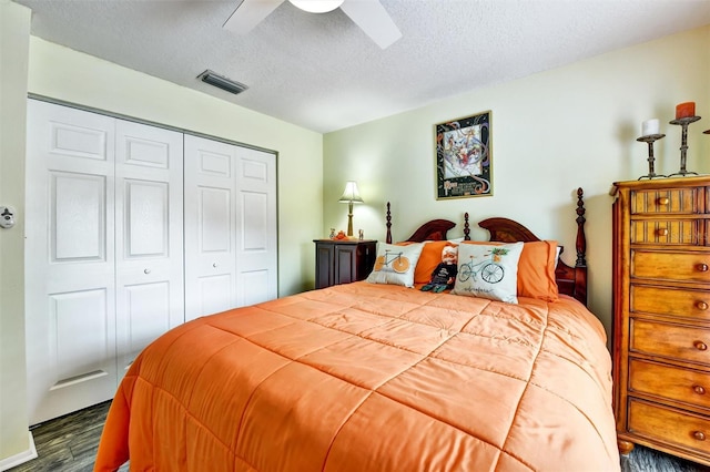 2700 Bayshore Blvd Unit 544, Dunedin, FL 34698 - bedroom featuring dark wood finished floors, a textured ceiling, a closet, and a ceiling fan