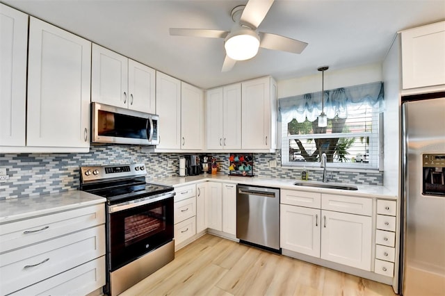 2700 Bayshore Blvd Unit 544, Dunedin, FL 34698 - kitchen featuring appliances with stainless steel finishes, light countertops, a ceiling fan, light wood-type flooring, and white cabinets