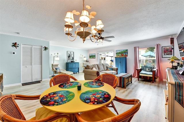 2700 Bayshore Blvd Unit 544, Dunedin, FL 34698 - dining room featuring a textured ceiling, a chandelier, light wood-type flooring, and a ceiling fan