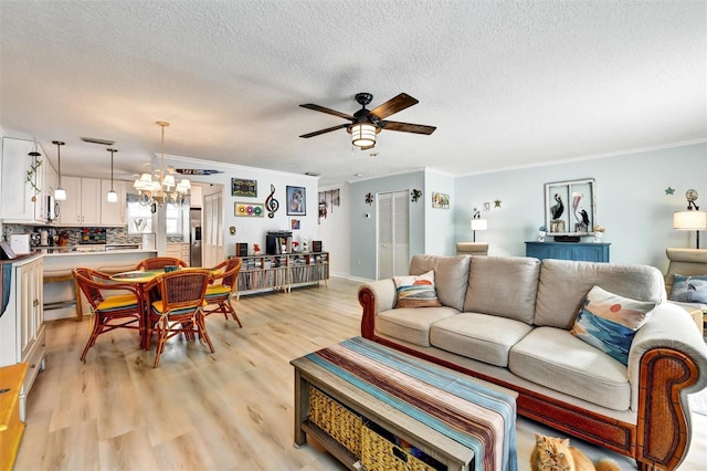 2700 Bayshore Blvd Unit 544, Dunedin, FL 34698 - living room with a ceiling fan, crown molding, a textured ceiling, light wood-type flooring, and a chandelier