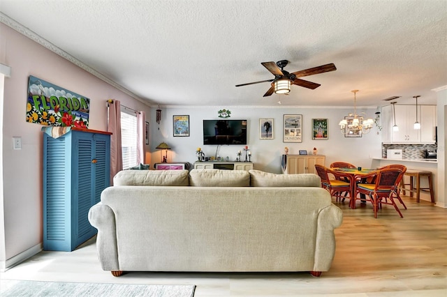 2700 Bayshore Blvd Unit 544, Dunedin, FL 34698 - living area with a ceiling fan, light wood-style floors, crown molding, a textured ceiling, and a chandelier
