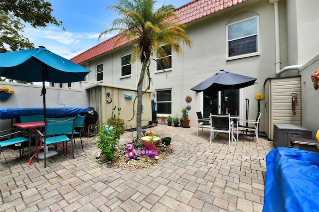 2700 Bayshore Blvd Unit 544, Dunedin, FL 34698 - back of house featuring outdoor dining area, a patio, stucco siding, and a tiled roof